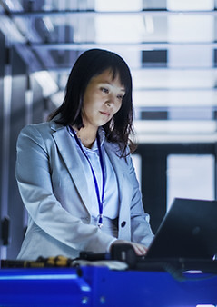 Female employeee working in a server room